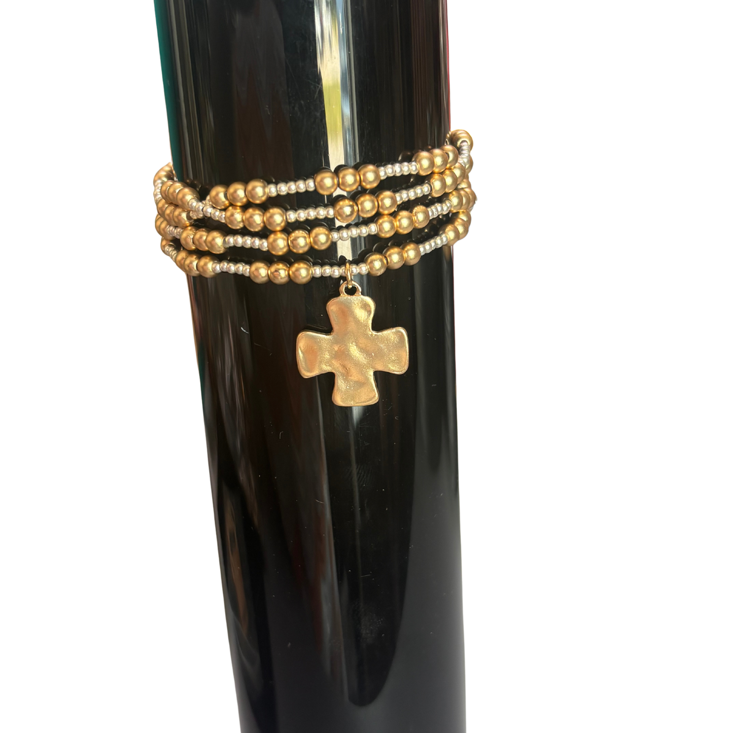 Elegant beaded bracelet featuring a striking cross pendant crafted with lustrous gold and silver beads. This Perdido Gems design combines spiritual symbolism with timeless style, making it perfect for everyday wear or meaningful gifting. The mixed-metal beadwork adds sophistication and versatility to any jewelry collection.