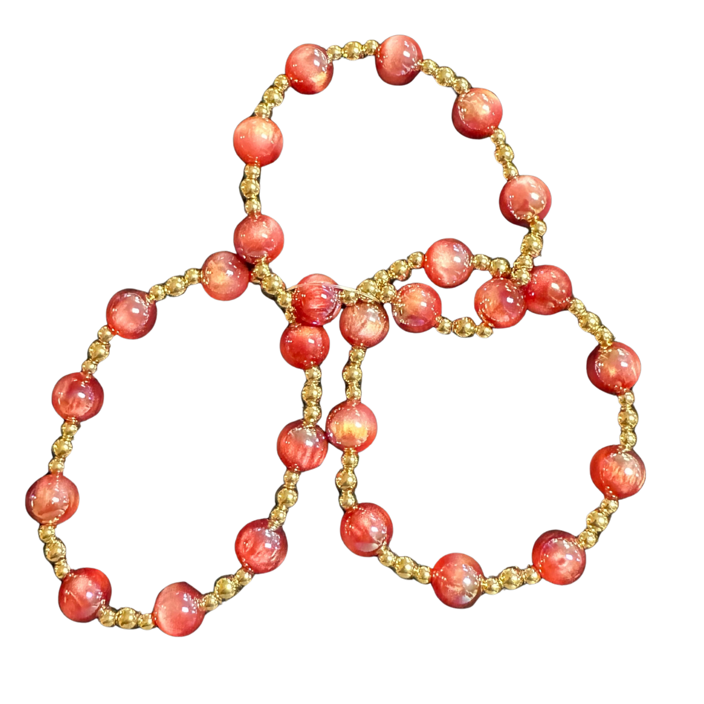 Elevate your accessory collection with this curated set of three beaded bracelets from Perdido Gems. Each piece features vibrant red and gold beads strung on a comfortable, stretchy band that adapts to your wrist for an effortless fit. The rich color combination offers versatile styling options—wear them individually for understated elegance or stack them together for a bold, layered statement. Perfect for everyday wear or special occasions, these bracelets deliver quality craftsmanship and timeless appeal