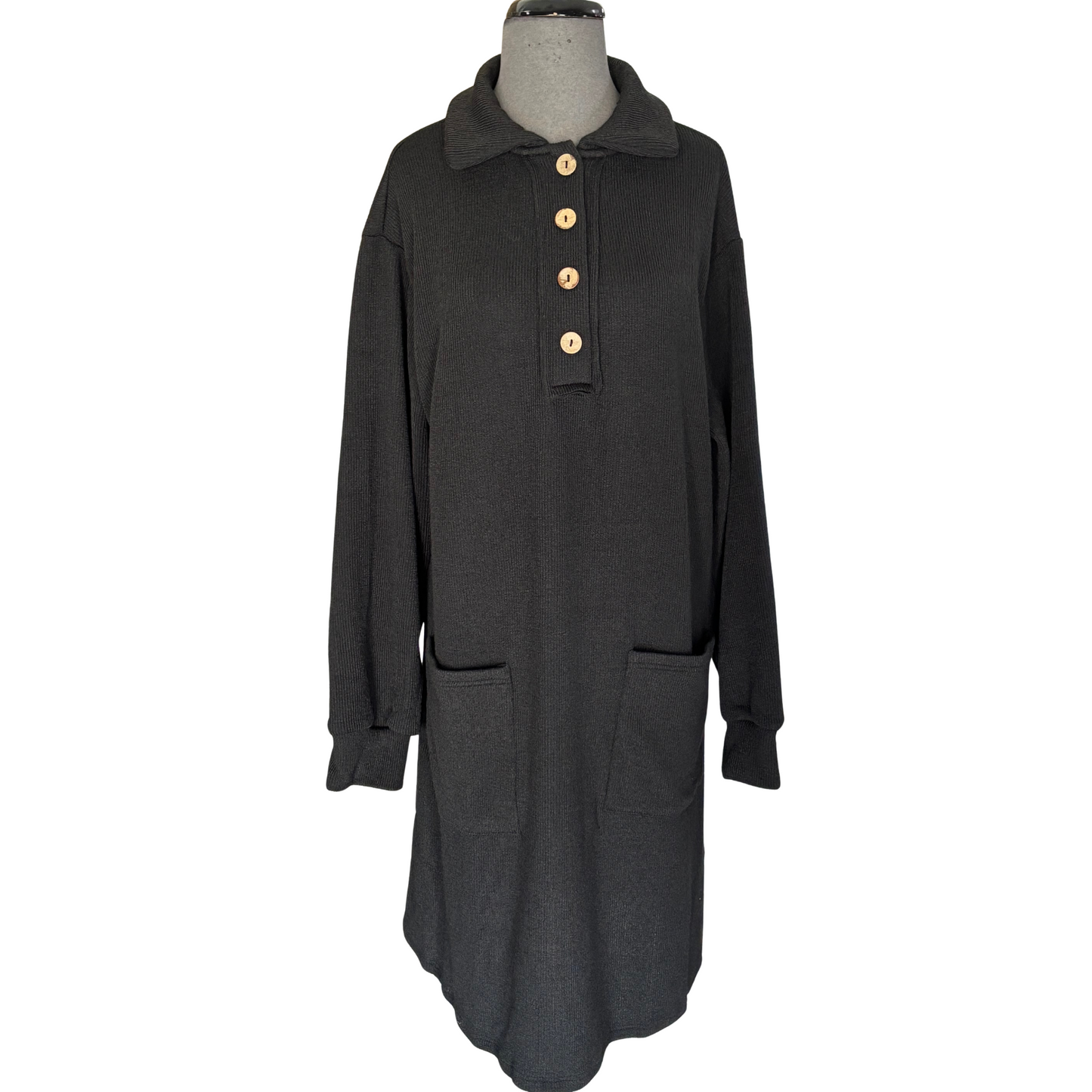 This black, long sleeve knit dress from She + Sky features a classic half button-up design with a structured collar for a polished look. Practical pockets add everyday convenience, while the soft knit fabric ensures comfort throughout your day. Ideal for layering or wearing on its own, this dress combines effortless style with functional details.