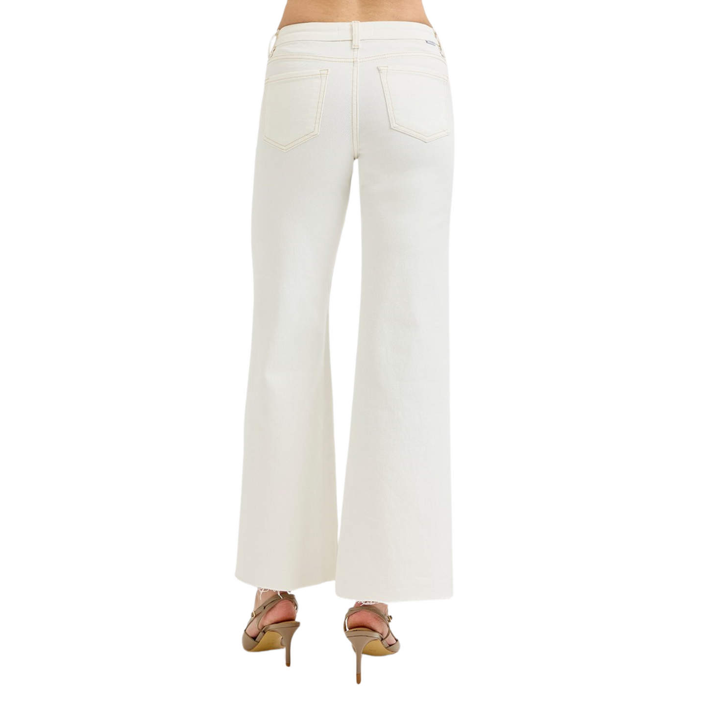 These cream-colored Mid Rise Wide Leg Pants from Risen offer a sophisticated silhouette with a comfortable mid-rise fit. The wide-leg design provides ease of movement and a flattering drape, making them ideal for both professional and casual settings. Crafted to combine style and comfort, these pants are a versatile addition to any wardrobe.