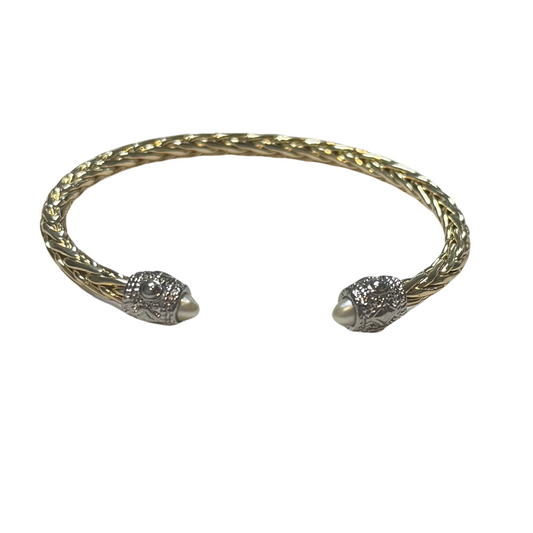 Crafted with high-quality gold, this elegant twisted bangle is a must-have accessory. The exquisite pearl accent adds a touch of sophistication to any outfit. Elevate your style with this versatile and timeless cuff bangle.