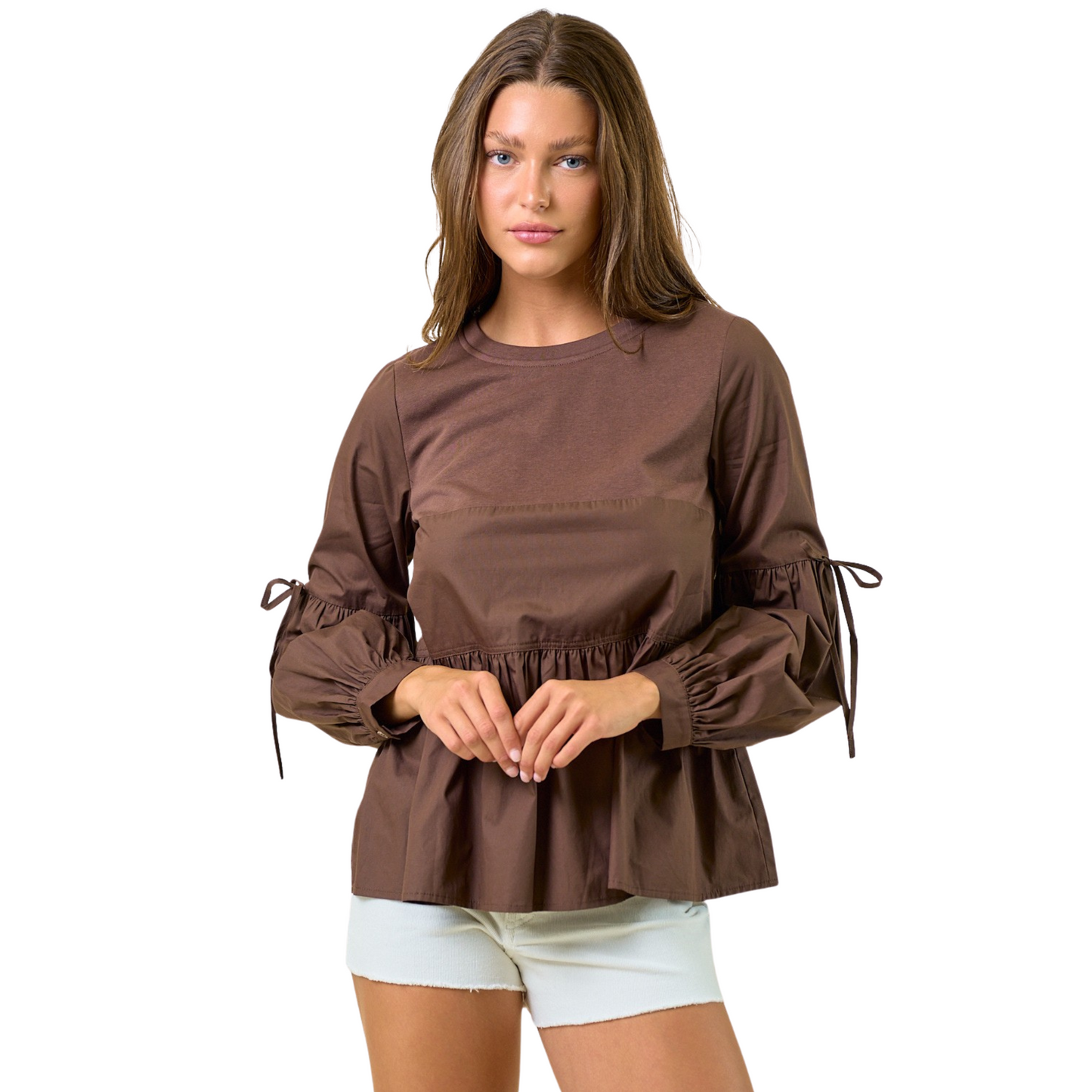 This long sleeve peplum blouse from Doe & Rae features a rich dark brown color that adds warmth and versatility to any wardrobe. Its elegant puff sleeves and classic round neck create a flattering silhouette while maintaining comfort and style. Ideal for both professional and casual settings, this blouse pairs effortlessly with various bottoms, making it a sophisticated choice for the modern woman.