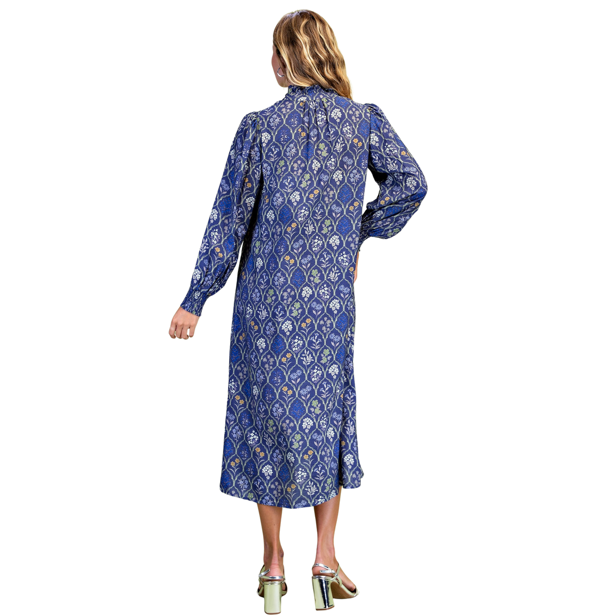 Discover effortless elegance with this stunning Floral Tile Midi Dress by GiGio. Rendered in a captivating blue base adorned with delicate floral tile print, this piece combines timeless charm with contemporary style. The ruffled collar adds a touch of feminine sophistication, while smocked long sleeves provide both comfort and visual interest. The button-down design allows for easy layering and styling versatility, making it perfect for transitions from day to evening.