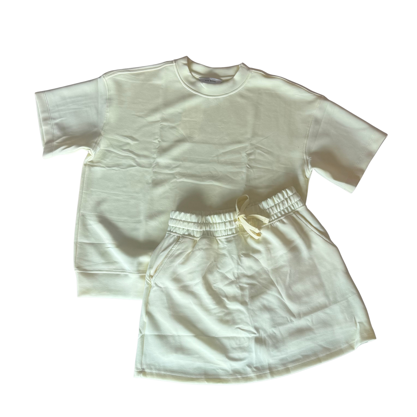 Elevate your casual wardrobe with this versatile Modal Poly Span Top and Skort Set from Rae Mode. The soft lemonilla-colored short sleeve top pairs perfectly with the coordinating drawstring skort, creating an effortless, put-together look. Crafted from a breathable modal and poly span blend, this set offers comfort and flexibility for everyday wear. The drawstring waist on the skort provides an adjustable fit, while the classic basic top design works seamlessly with your existing pieces.