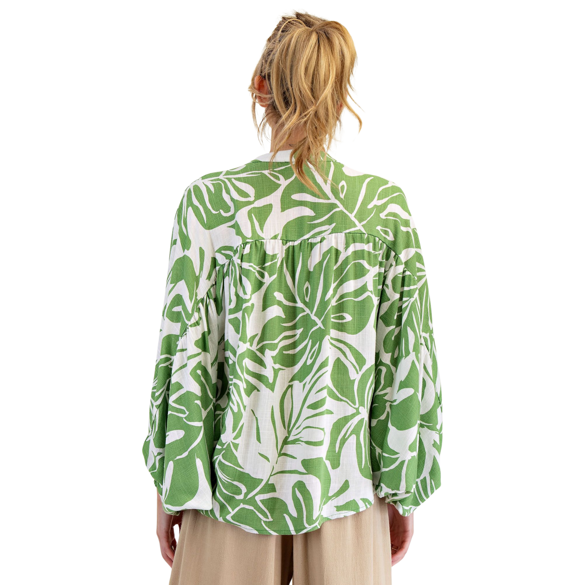 This printed rayon linen button-down shirt features long dolman sleeves with smocked cuffs and a notched neckline for a refined silhouette. The rounded hem and ruched detailing on the chest and back add subtle texture and dimension. Crafted with a relaxed, loose fit and adorned with an elegant leaf print, this shirt combines comfort with sophisticated style, making it a versatile addition to any wardrobe.