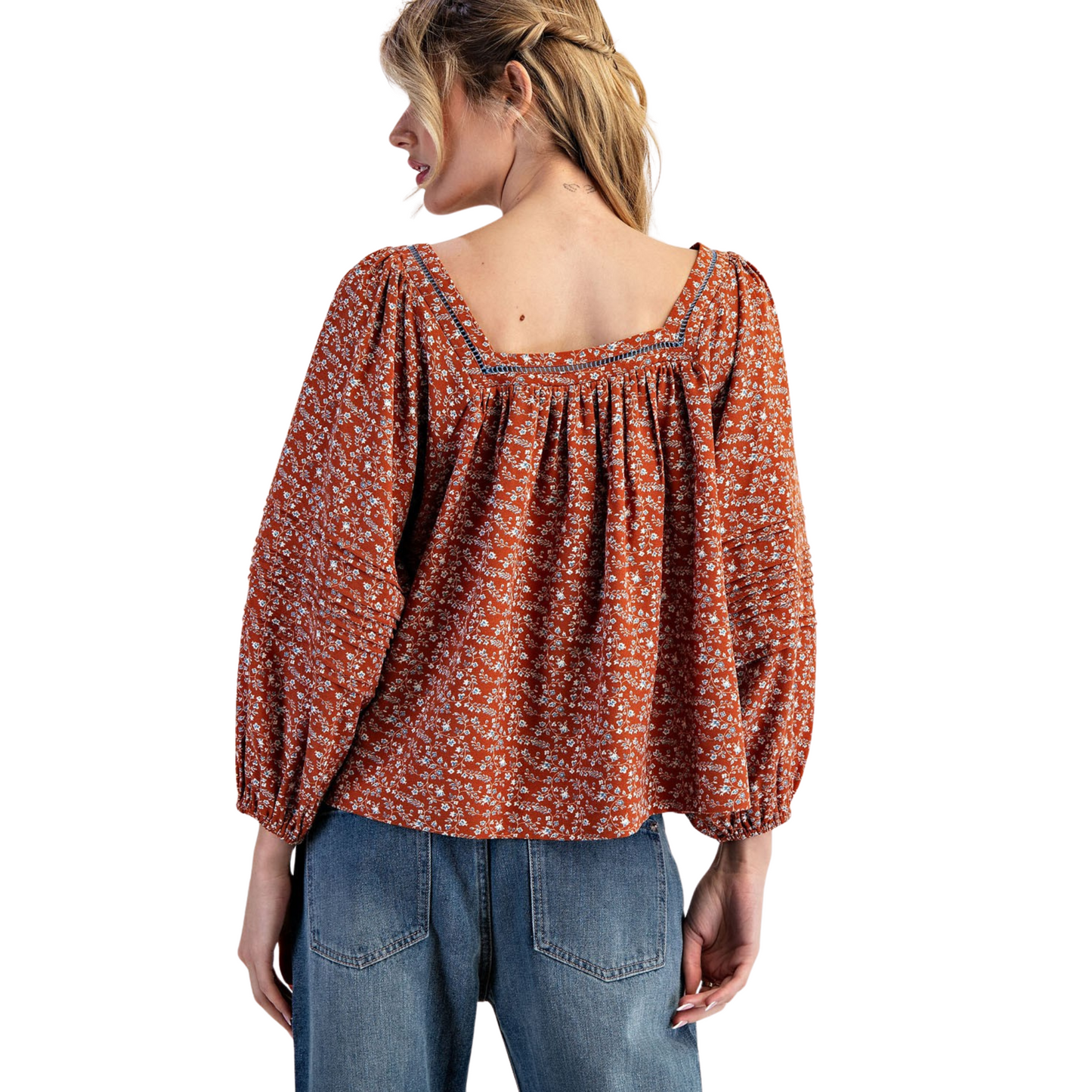 This elegant long-sleeve blouse features a flattering square neckline and a delicate floral print set against a warm clay color. Designed for a refined silhouette, it combines classic charm with modern sophistication, making it ideal for both professional settings and casual occasions. The breathable fabric ensures comfort throughout the day while the subtle floral pattern adds a touch of understated femininity.