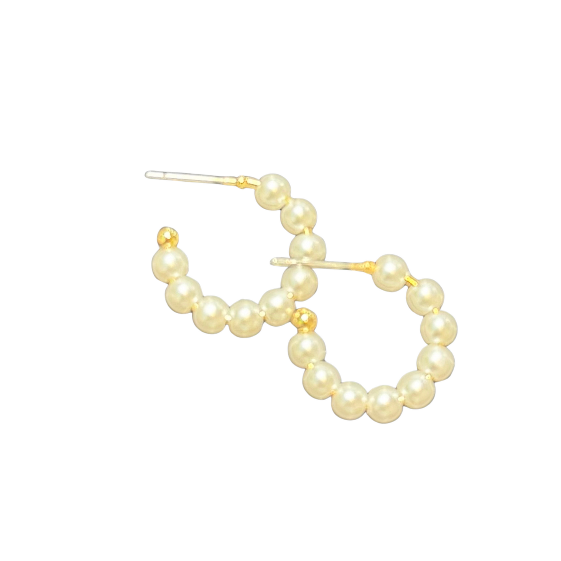 Featuring a timeless design, these Small Pearl Hoops by Ete are a must-have for every jewelry collection. The delicate hoop earrings are lined with lustrous pearls, adding a touch of elegance and sophistication to any outfit. Upgrade your style with these stunning hoops.
