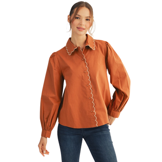 Elevate your wardrobe with this sophisticated Jodifl button-down top, featuring a distinctive scalloped collar that adds refined detail to any ensemble. The rich toffee hue offers versatile styling options, pairing effortlessly with denim, trousers, or skirts for both professional and casual occasions. Long sleeves provide coverage and elegance, while the structured button-front design ensures a polished, put-together appearance. A timeless piece that transitions seamlessly from office to weekend wear.