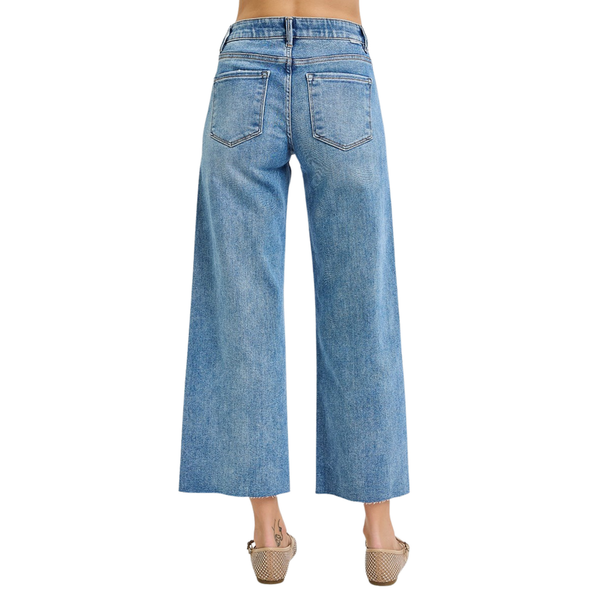 These mid-rise cropped jeans from Risen feature a flattering tummy control design and a wide-leg silhouette for comfort and style. The medium wash adds versatile appeal, while the raw hem provides a modern, edgy finish. Perfect for a polished yet relaxed look.