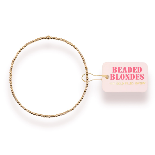 Elevate your everyday style with this delicate 2mm Beaded Bracelet from Beaded Blondes. Crafted with lustrous gold beads, this stretchy bracelet offers effortless comfort and versatility. The slim profile makes it perfect for layering or wearing solo, while the quality construction ensures lasting wear. A timeless accessory that complements any look.
