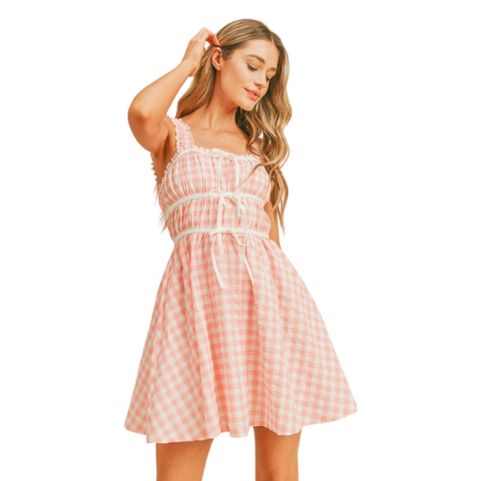 Stay comfortable and on-trend this summer with the Gingham Flared Dress. This flattering mini dress features a classic gingham print in a stylish pink and white color combination. Perfect for both casual and dressier occasions, you'll love this must-have summer look.
