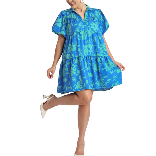 This plus size tiered midi dress features a beautiful floral print in a vibrant turquoise blue color. The tiered design not only adds a stylish touch, but also creates a flattering, flowy silhouette. Perfect for any occasion, this short sleeve dress will make you stand out in confidence and style.