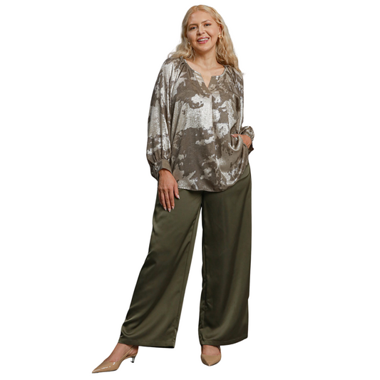 The Umgee Metallic V-Notched Top features a stylish v-neck and abstract design in a chic taupe color. Its unique design blends fashion and comfort, making it a must-have addition to any wardrobe. Elevate your look with this effortlessly trendy top.