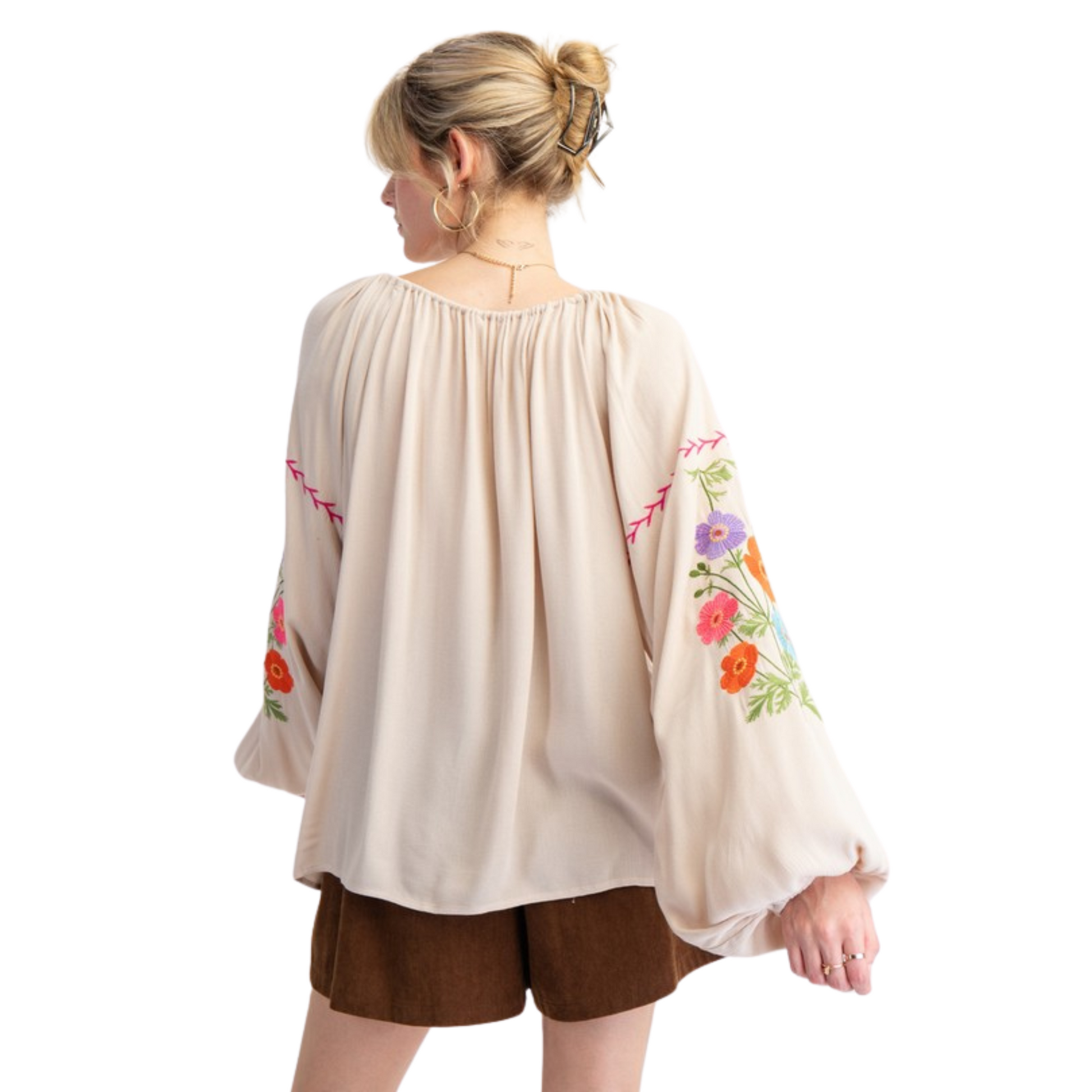 Expertly crafted from lightweight rayon gauze, this embroidered babydoll tunic features long bubble sleeves, a rounded neckline with adjustable tassel tie, ruched detailing, dropped shoulders, and elastic cuffs. The relaxed and loose fit provides comfort and style. Perfect for any casual or dressed-up occasion.