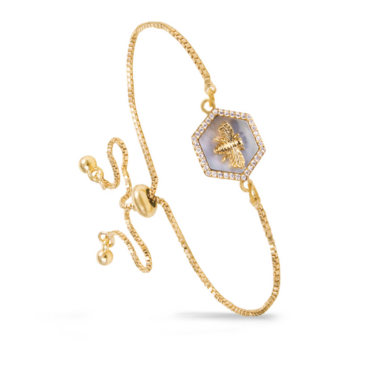 Expertly crafted with a pull chord adjustment, this Hexagon Bee Bracelet features a stunning gold and rhinestone accent, complete with a delicate bee pendant. The unique hexagon design adds a touch of elegance to any outfit. Adjust to your perfect fit for effortless style.