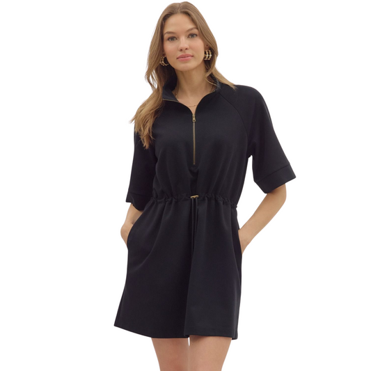 This black Zip Front Pullover Dress by Entro combines effortless style with functional design. Crafted from lightweight knit fabric, it offers a comfortable, breathable fit without being sheer. The short sleeves and high neck with zip-front closure add modern appeal, while the adjustable drawstring at the waist allows for a customizable silhouette. Practical side pockets enhance convenience, making this unlined mini dress perfect for versatile everyday wear.