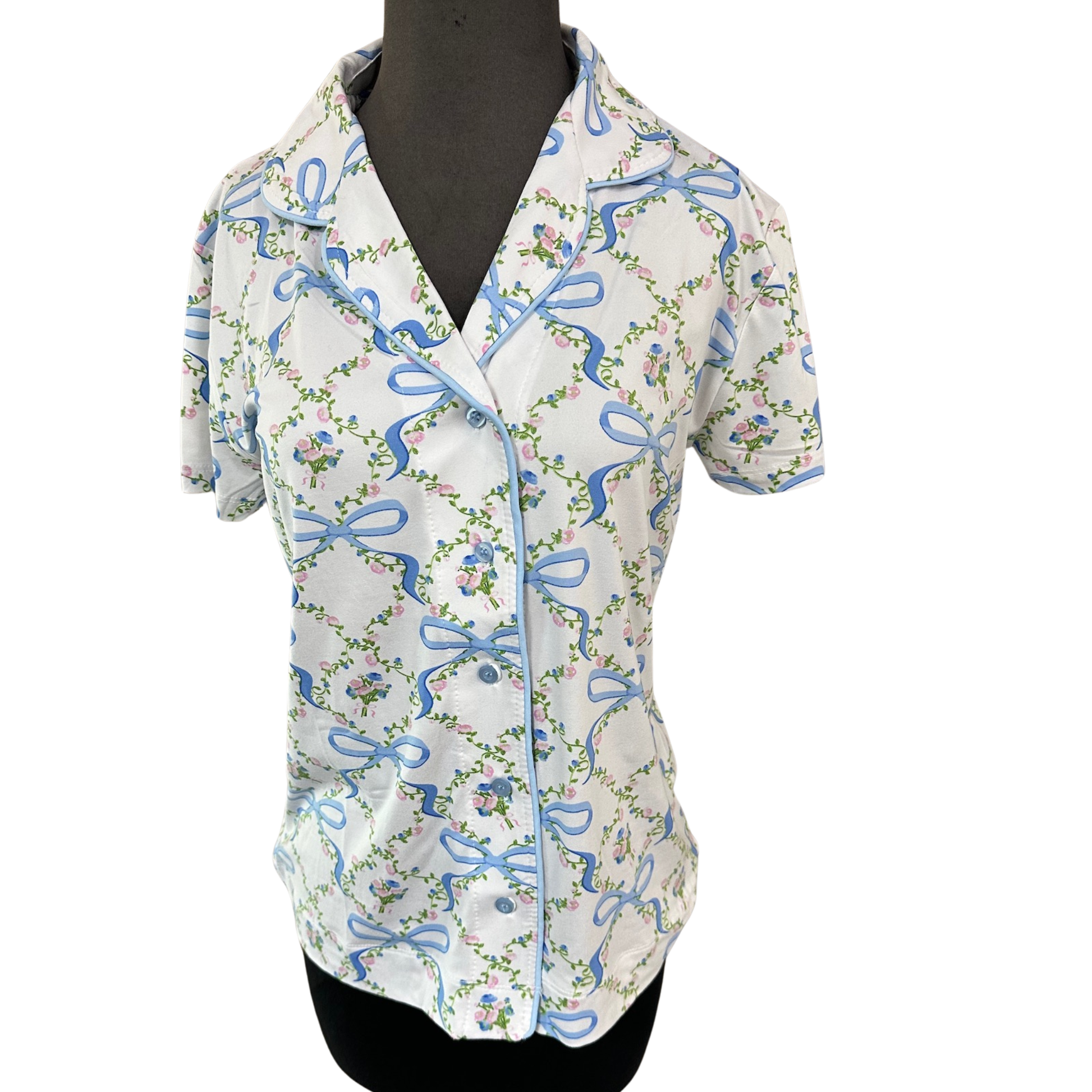 Blossom and bow print pajama top by Amanda Blu, crafted in soft white fabric with short sleeves and classic button-up closure. This charming design combines timeless floral motifs with delicate bow accents for a sophisticated sleepwear essential. The structured button front allows for easy dressing and layering versatility, while the relaxed fit ensures comfort throughout the night. Perfect for those who appreciate quality craftsmanship and refined details in their loungewear collection.