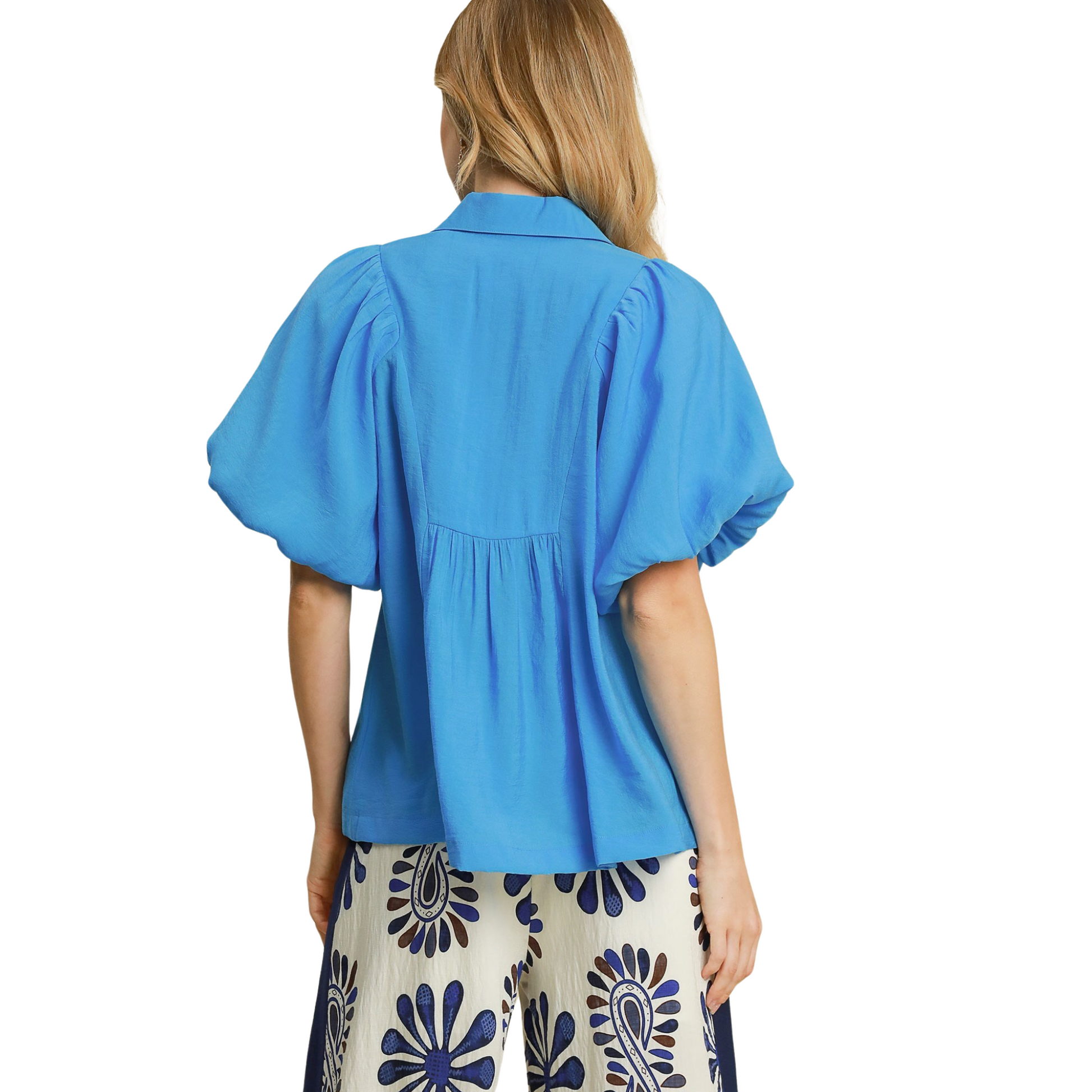 Expertly designed by Umgee, this Bubble Sleeve Smocked Top is a must-have piece for your wardrobe. The blue color adds a touch of sophistication while the smocked detail and exaggerated bubble sleeve create a trendy and flattering silhouette. Perfect for any occasion with its classic v neck design.