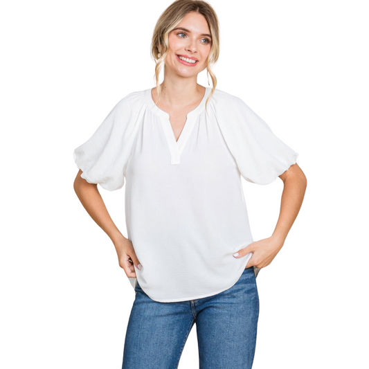 The Balloon Sleeve Top in off white features a v neck design and trendy bubble sleeves. With a sophisticated and versatile style, this top is perfect for any occasion. Enhance your wardrobe with this must-have fashion piece.