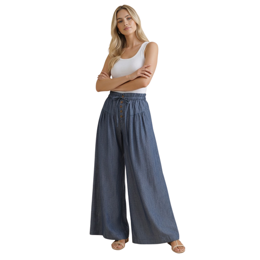 Effortless comfort meets timeless style with these Wide Leg Chambray Pants from Haptics. Crafted in a classic denim color, these pants feature a relaxed wide-leg silhouette that flatters all body types. The elastic waistband provides all-day comfort and ease of movement, while front button closures add a polished touch. Perfect for casual outings or dressed-up occasions, these versatile pants are a wardrobe essential.