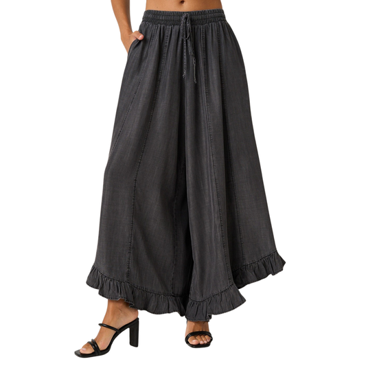 Elevate your everyday style with these Washed Chambray Ruffle Pants by Mittoshop. Crafted in soft, breathable chambray fabric, these wide-leg trousers feature a charming ruffle hem that adds movement and dimension. The adjustable drawstring waist ensures a comfortable, customizable fit for all-day wear. Perfect for casual outings or dressed-up occasions, this versatile piece transitions seamlessly from season to season.