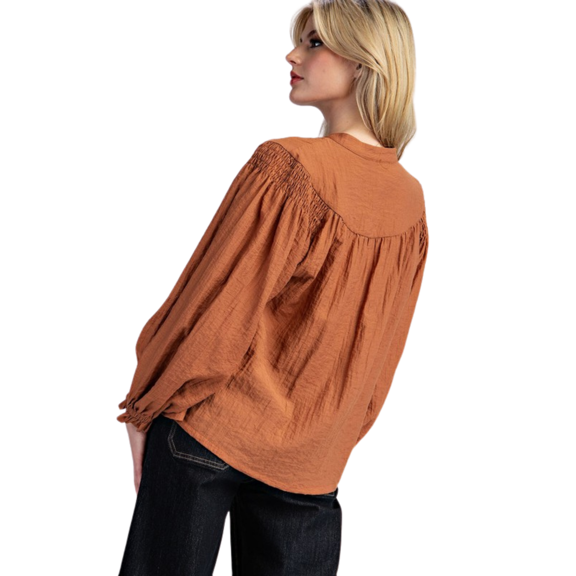 Solid long sleeve blouse top featuring a notched neckline, added seams and pinching for detail, smocked shoulders, elastic cuffs and is a lightweight material, perfect for transitioning seasons.