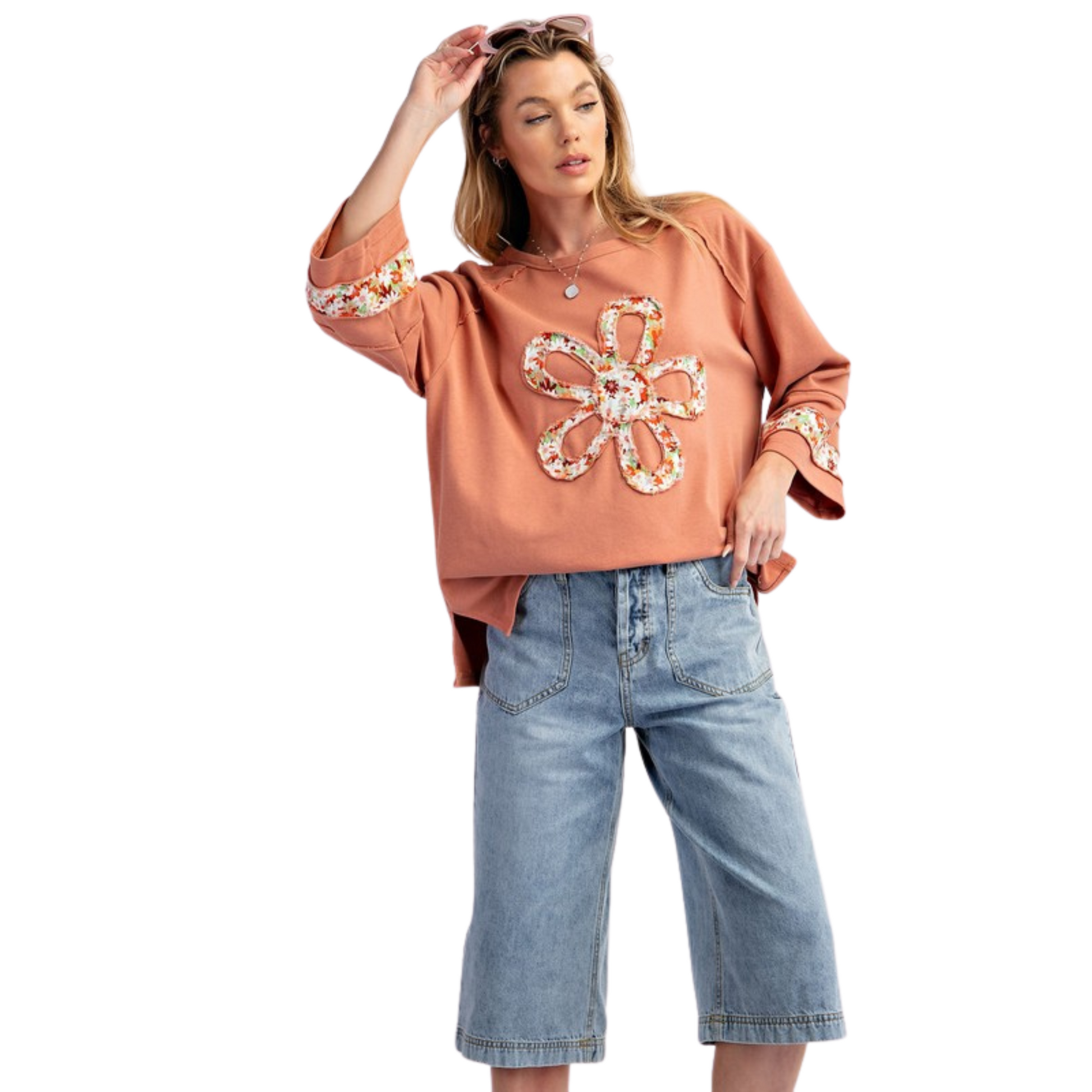 Introducing the Flower Patch Terry Knit Top by Easel. In a beautiful coral color, this long sleeve top features a delicate floral accent for a touch of elegance. Made with high-quality terry knit fabric, this top is both stylish and comfortable, perfect for any occasion.