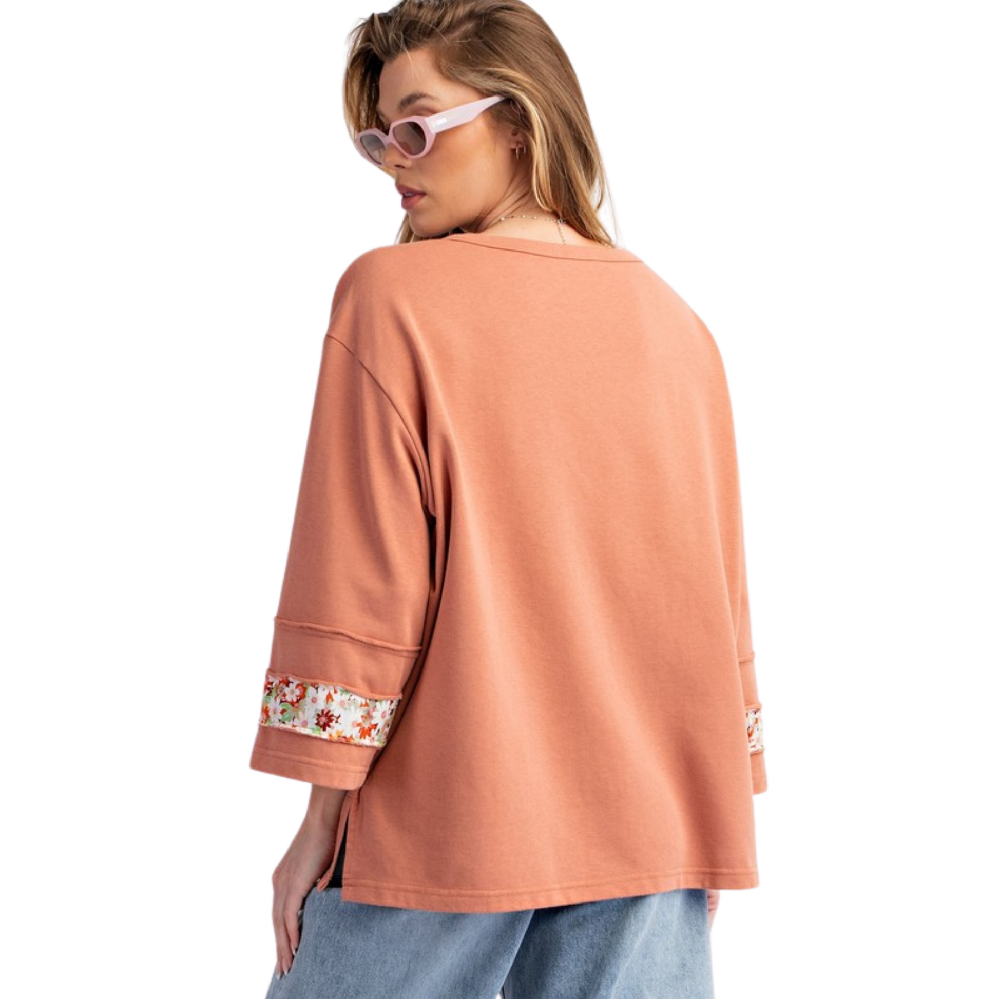 Introducing the Flower Patch Terry Knit Top by Easel. In a beautiful coral color, this long sleeve top features a delicate floral accent for a touch of elegance. Made with high-quality terry knit fabric, this top is both stylish and comfortable, perfect for any occasion.