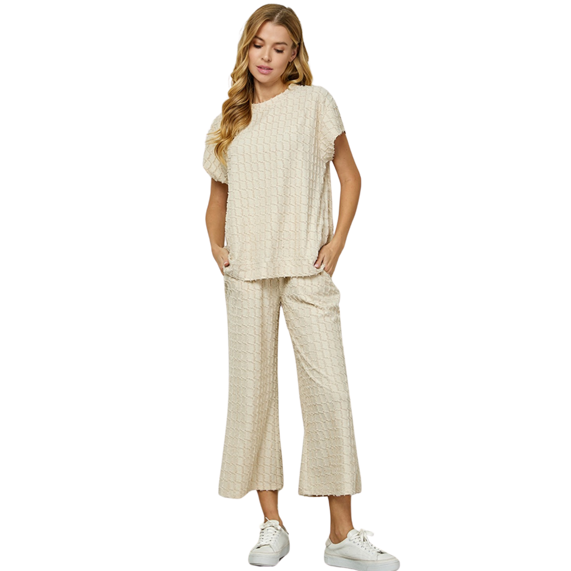 This top and bottom set features a classic cream color, short cap sleeve top, and textured bottom pants. Crafted from a lightweight material, this set is perfect for leisure or formal occasions. Its timeless look and comfortable fit make it a must-have for any wardrobe.