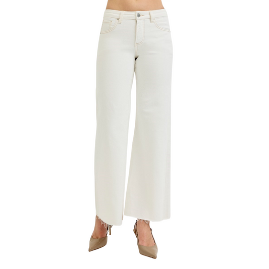 These cream-colored Mid Rise Wide Leg Pants from Risen offer a sophisticated silhouette with a comfortable mid-rise fit. The wide-leg design provides ease of movement and a flattering drape, making them ideal for both professional and casual settings. Crafted to combine style and comfort, these pants are a versatile addition to any wardrobe.