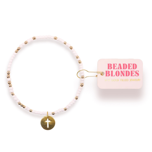 Elevate your wrist with this stunning Cross Cutout Charm Bracelet from Beaded Blondes. Crafted with lustrous white and gold beads, this piece combines timeless elegance with meaningful symbolism. The intricate cut-out cross charm serves as a beautiful focal point, making it perfect for everyday wear or special occasions. A versatile accessory that complements any style while adding a touch of grace and sophistication to your look.