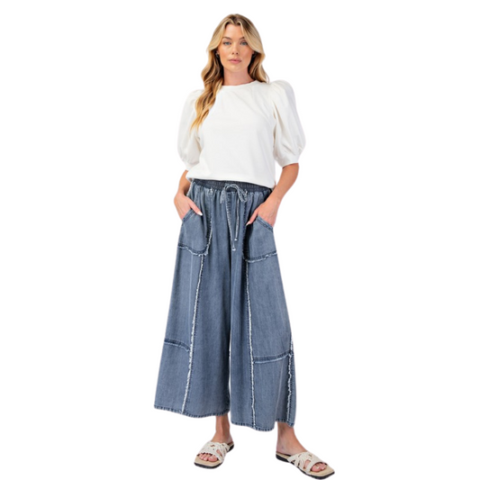 Update your wardrobe with our Chambray Palazzo Pants! These washed denim pants offer a relaxed and loose fit, perfect for a comfortable and stylish look. The smocked waistband with an adjustable tie provides a flattering silhouette while the frayed panel detailing adds a touch of uniqueness. With functional front pockets and a wide leg design, these pants are both practical and chic.