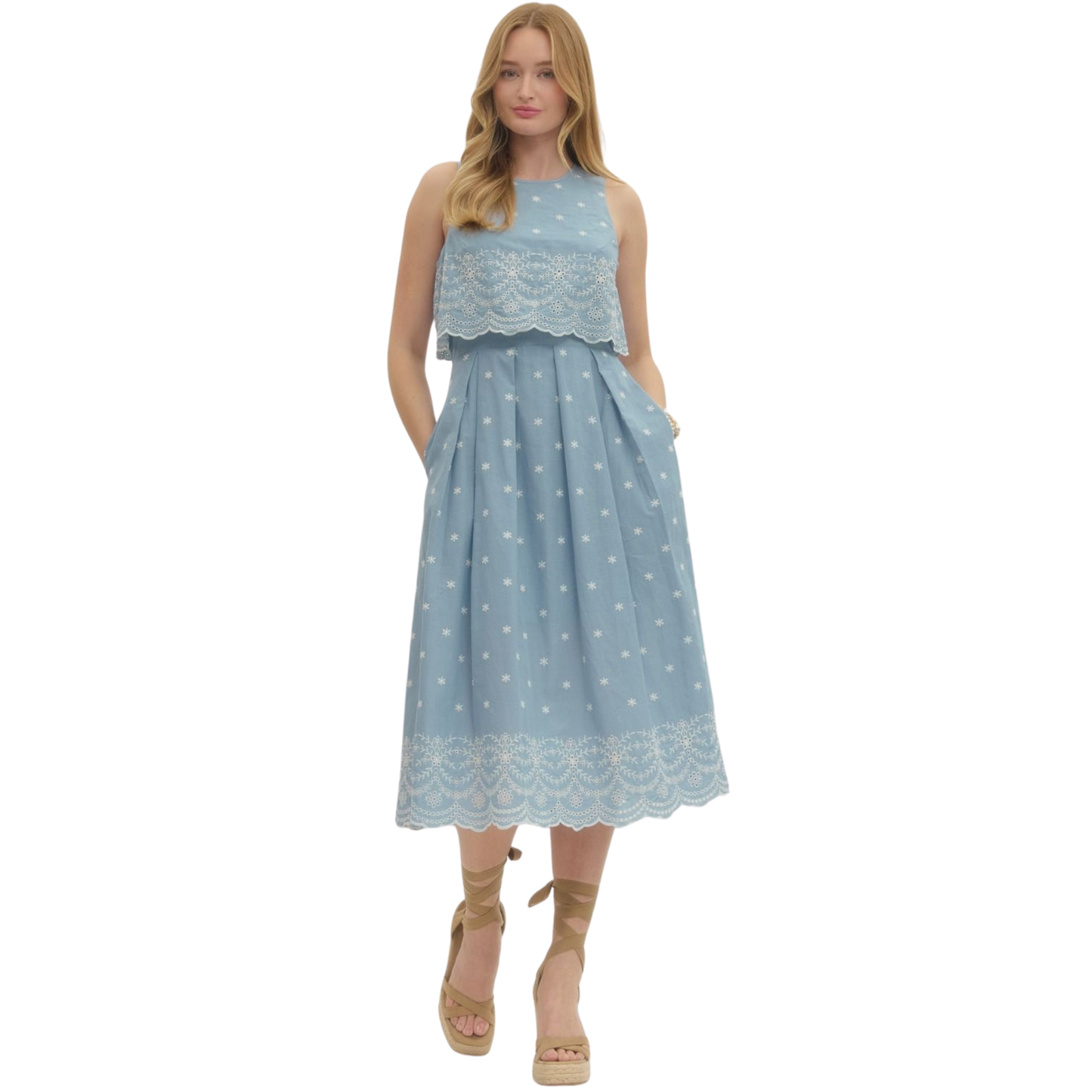 This Entro midi dress combines effortless elegance with thoughtful design details. The light blue fabric provides a versatile canvas for the intricate embroidery that adorns the piece, adding visual interest and sophistication. The sleeveless silhouette offers breathability and a modern aesthetic, while the midi length ensures a polished, refined look suitable for various occasions. Whether styled casually with sneakers or dressed up for an event, this dress delivers both comfort and contemporary style.
