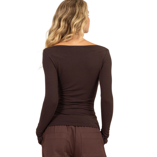 This boat neck long sleeve top in espresso features a flattering boat neckline and a slim fit silhouette, making it an essential addition to your wardrobe. Crafted from a soft, stretchy fabric, it ensures all-day comfort and a perfect fit. The long sleeves provide added warmth, while the simple design allows for versatile styling. Pair this elegant top with your favorite jeans, skirt, or shorts for a chic and polished look, suitable for both casual and dressy occasions.&nbsp;