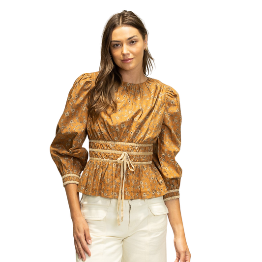 Elevate your wardrobe with the HEYSON Smocked Waist Peplum Top in a warm cinnamon hue. Featuring a delicate floral pattern, this top combines classic femininity with modern styling. The smocked waist ensures a flattering, comfortable fit while the peplum silhouette adds subtle shape and elegance. Perfect for transitioning from casual days to chic evenings, this piece offers both versatility and timeless appeal.