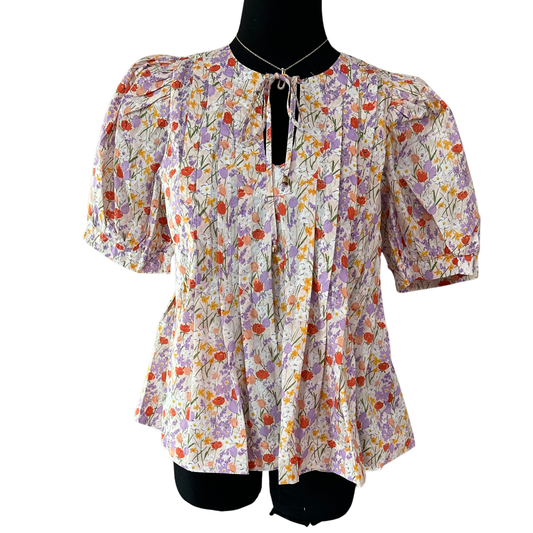 Effortless elegance meets comfort in this charming Entro floral top. Featuring a delicate lavender palette with an intricate floral print, this short-sleeve piece showcases a flattering tie neckline and refined pleated detailing throughout. Perfect for casual outings or dressed-up occasions, the breathable fabric and thoughtful design make it a versatile wardrobe essential. Pair with your favorite bottoms for an instantly polished look.
