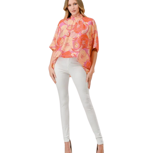 Introducing the Gemma Mock Tie Neck Top, a stylish and versatile addition to any wardrobe. With its vibrant floral print in orange, pink, and yellow, this top adds a pop of color to any outfit. The tie neck detail adds a touch of elegance, while the drape top creates a flattering silhouette.