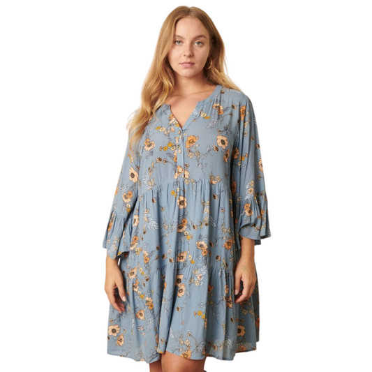 This Flower Print Babydoll Dress is crafted from lightweight Rayon Gauze fabric featuring a delightful flower print in a dusty blue color. The delicate round neckline and slit front with a button closure accentuate a timeless silhouette. With a classic look and a comfortable fit, it’s perfect for any occasion.