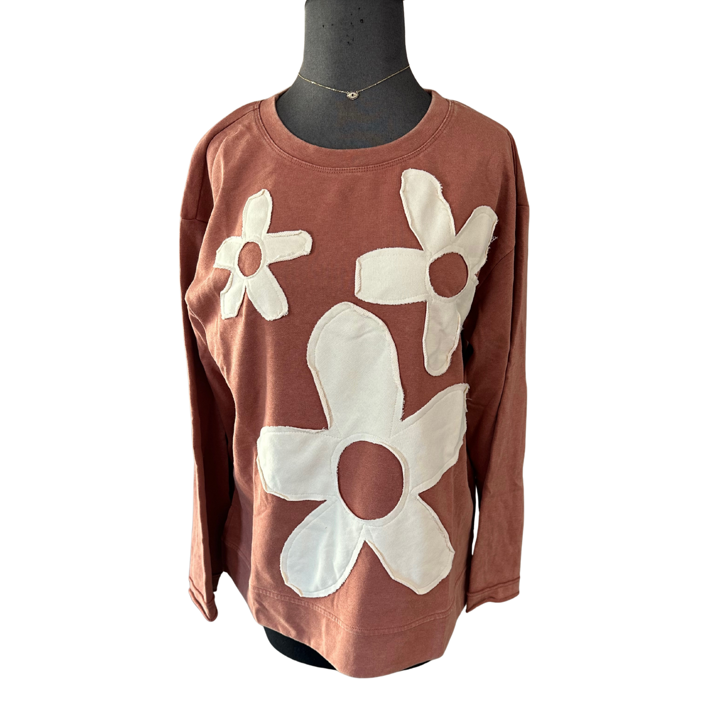 Elevate your casual wardrobe with this Jodifl sweatshirt, featuring a charming flower patch design set against a warm brick color. The long sleeves provide comfortable coverage for layering through transitional seasons, while the thoughtful patch detailing adds visual interest and personality to an otherwise classic silhouette. Perfect for those who appreciate quality basics with subtle design elements that distinguish them from everyday wear.