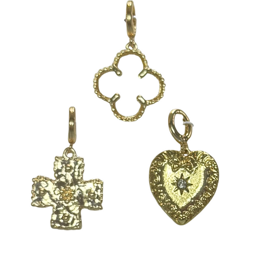 Elevate your accessory collection with this Set of Three Scarf Necklace Charms by Golden Stella. Featuring delicately crafted gold charms shaped as a clover, heart, and cross, this trio offers both style and symbolism. Designed to effortlessly enhance scarves or necklaces, these charms add a refined, meaningful accent to your ensemble with expert craftsmanship you can trust.