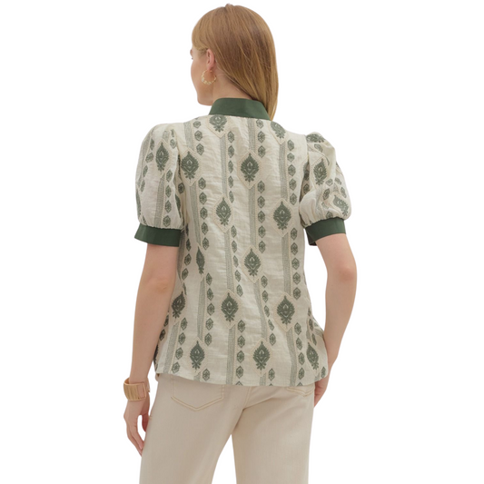 This lightweight woven top showcases an abstract embroidered pattern with short puff sleeves, adding volume and a touch of femininity. Its caftan-inspired neckline with contrasting accents elevates the design, offering a unique focal point. Unlined and non-sheer, it ensures comfortable wear without bulk. Perfect for layering or as a standalone piece, this green top blends artistic detail with breathable fabric for an effortlessly refined look.