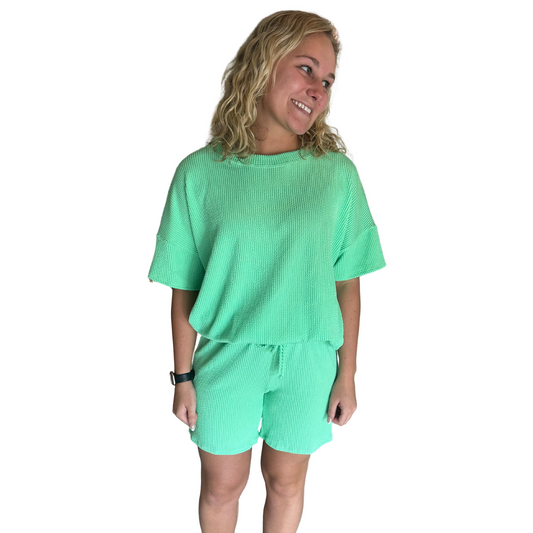 This Ribbed Top and Bottom Set features a stylish gio gren color and is perfect for warm weather with its short sleeve design and comfortable ribbed fabric. The matching shorts complete the look for effortless style. Stay trendy and comfortable with this set.