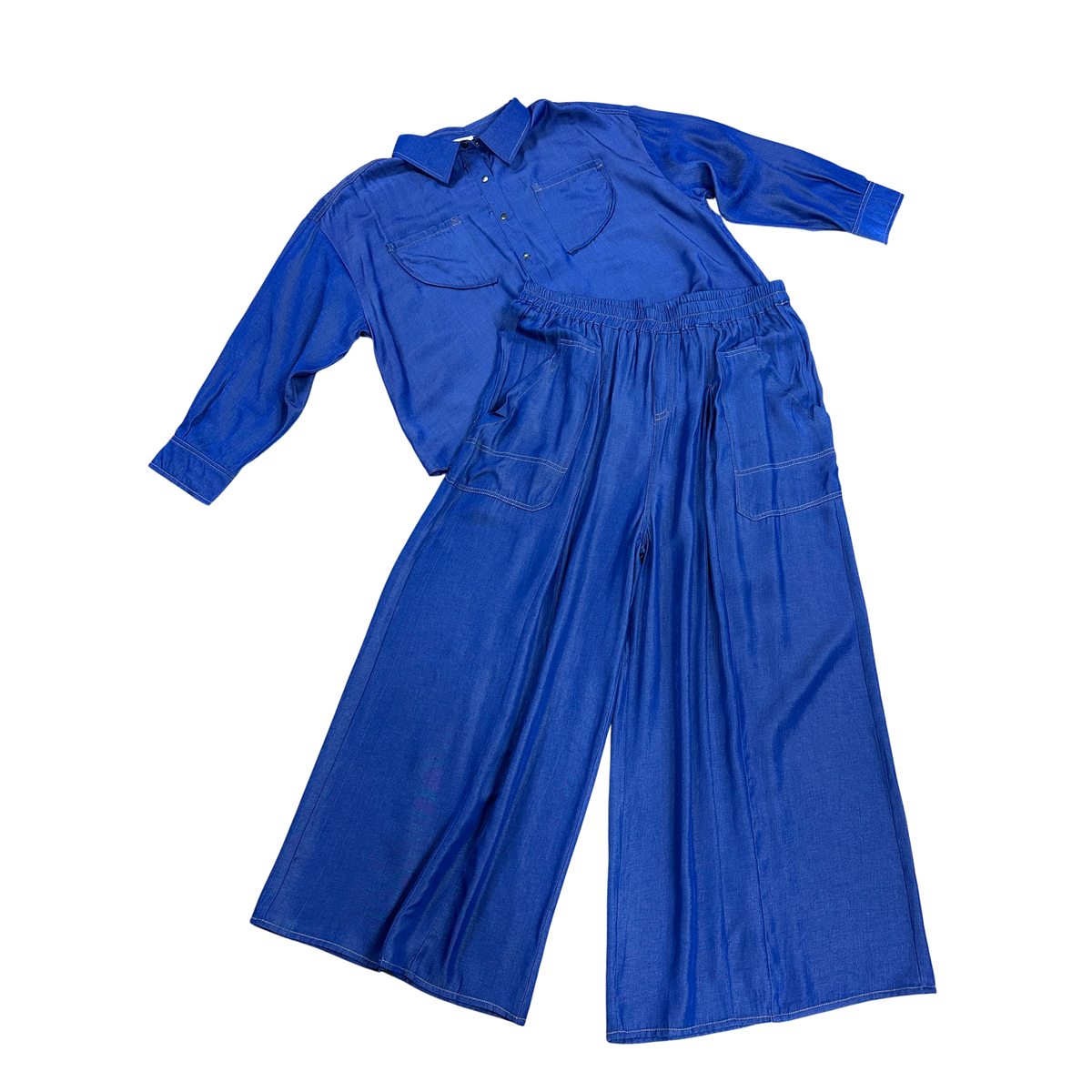 The perfect casual set combining comfort and style. This Very J brand ensemble features a button-up long sleeve top paired with wide-leg pants, both in a rich indigo color. The pants include a drawstring waist for an adjustable, relaxed fit. Ideal for laid-back days or effortless layering, this coordinated two-piece set offers versatile styling options for any season.