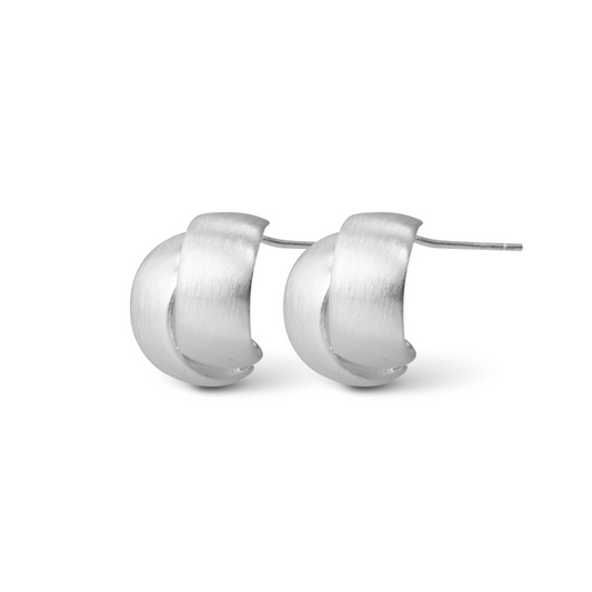 Expertly crafted with high-quality silver, these Audrey Interlocking Huggie Earrings feature a unique interlocking design that adds a modern twist to classic hoop earrings. Upgrade your everyday look with a touch of elegance and sophistication. Elevate your style with these must-have earrings.