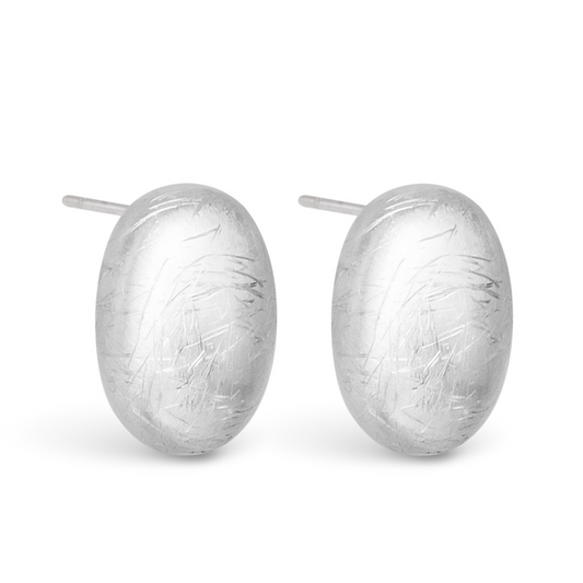 These Jane Matte Studs feature an elegant silver design with an oval shape and a sleek matte finish. These understated studs are perfect for adding a touch of sophistication to any outfit. Expertly crafted for quality and style.