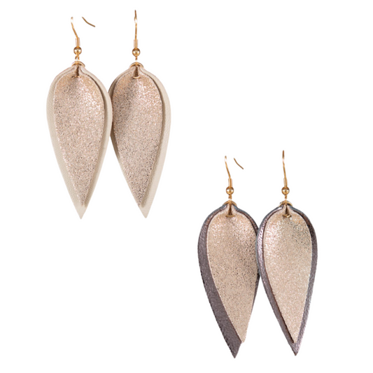 These Amanda Blu Leather Glitter Pucker Dangle Earrings offer a touch of glamour and elegance to any outfit. Available in beige or gunmetal, the glitter accents and leaf design add a subtle sparkle and charm. Perfect for any occasion, these dangle earrings are a must-have for any fashion-forward individual.