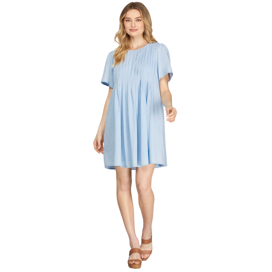 Elevate your everyday style with this charming pleated mini dress from She+Sky. Crafted in a soft light blue woven fabric, this short-sleeve design features elegant pleating throughout for a flattering silhouette. The mini length keeps things fresh and modern, while functional pockets add practical appeal. Perfect for casual outings, weekend brunches, or layering with your favorite jacket. A versatile wardrobe essential that transitions effortlessly from day to night.