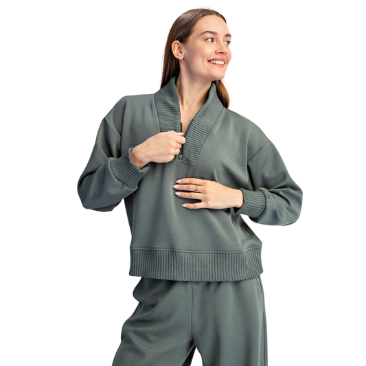 Elevate your everyday wardrobe with this Modal Scuba Luxe V-Neck Top from Rae Mode. Crafted in a sophisticated sage green, this long-sleeve top features a flattering v-neckline and quarter-zip design for versatile styling and easy layering. The luxurious modal fabric offers a soft, breathable feel perfect for all-day comfort. Whether dressed up or down, this timeless piece transitions seamlessly from casual outings to relaxed work settings.