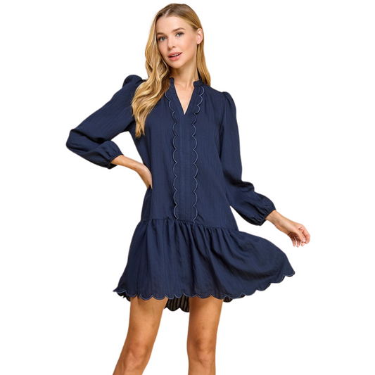 Expertly crafted with a charming scalloped detail on its split neckline, this navy mini dress showcases a timeless and elegant design. Its long sleeves offer versatility, while the pleated detail adds a touch of sophistication. Perfect for any occasion, this dress exudes a classic and refined look.