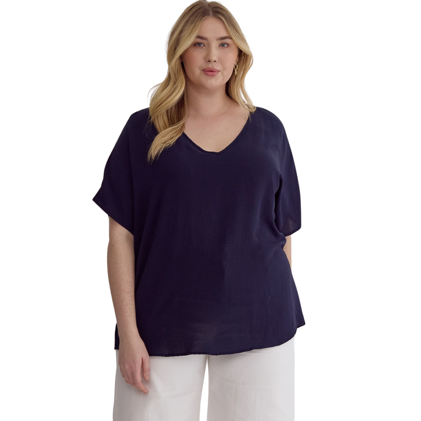 This solid v-neck top is perfect for those who prefer a little extra coverage. The asymmetrical rounded hem detail and semi-sheer fabric add a touch of style, while the lightweight woven material keeps you comfortable all day long. Available in navy and plus size.